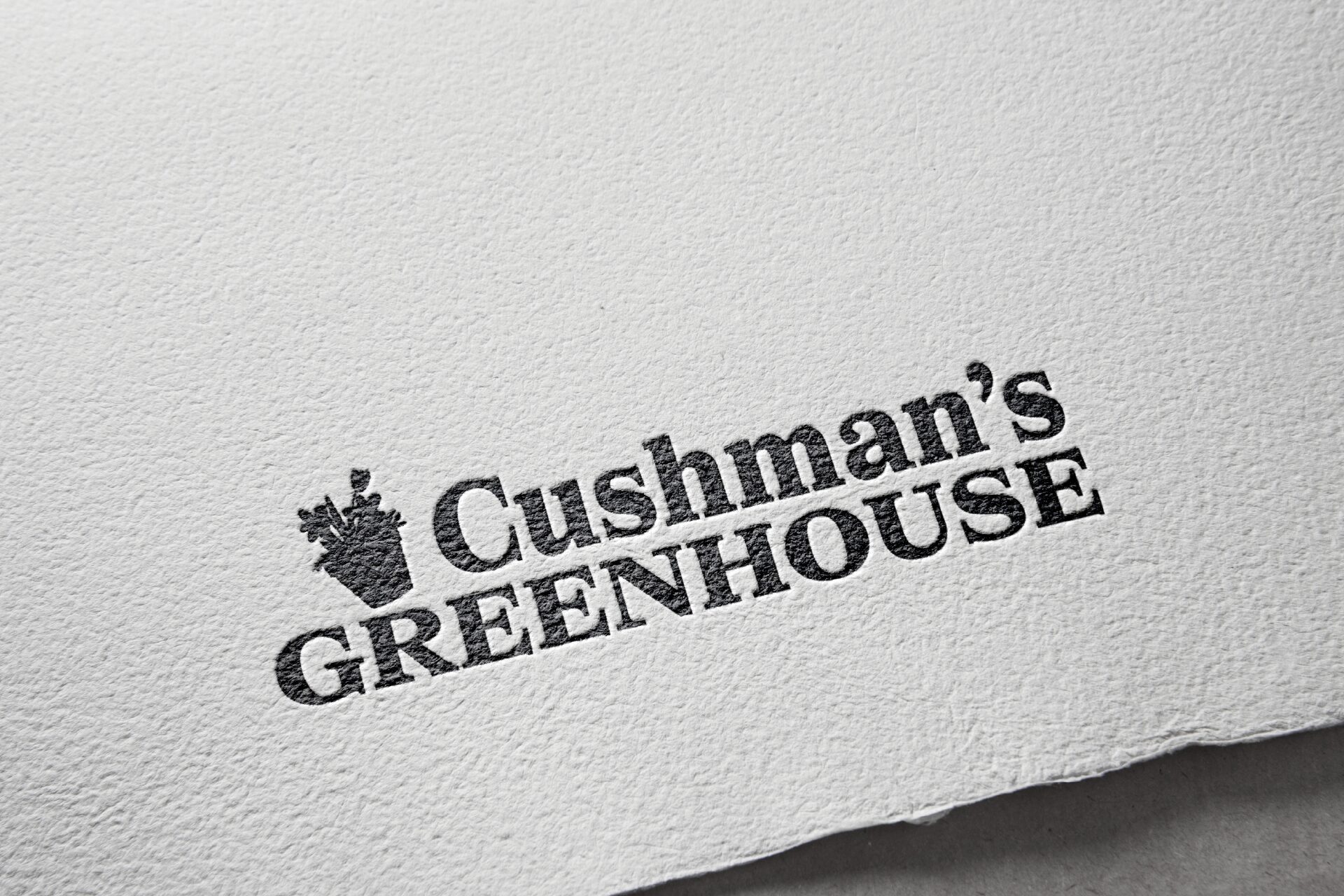 Embossed “Cushman’s Greenhouse” logo on textured paper